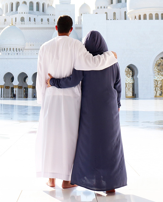 un couple vu de dos devant un tres beau batiment